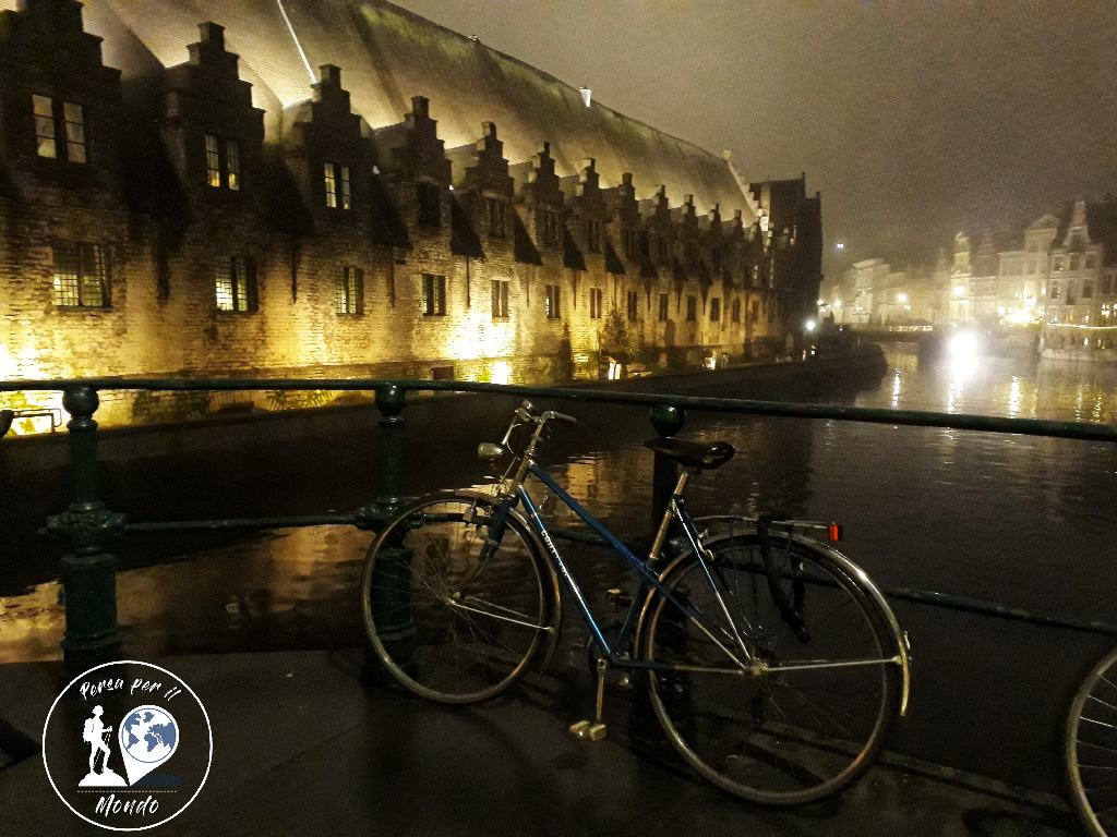 Bicicletta nei pressi di un canale, sullo sfondo tipico edificio fiammingo illuminato